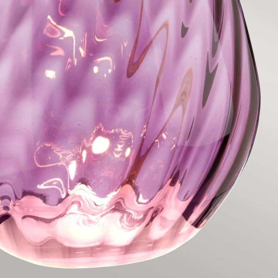 Gros plan sur le verre violet moucheté et ses reflets lumineux