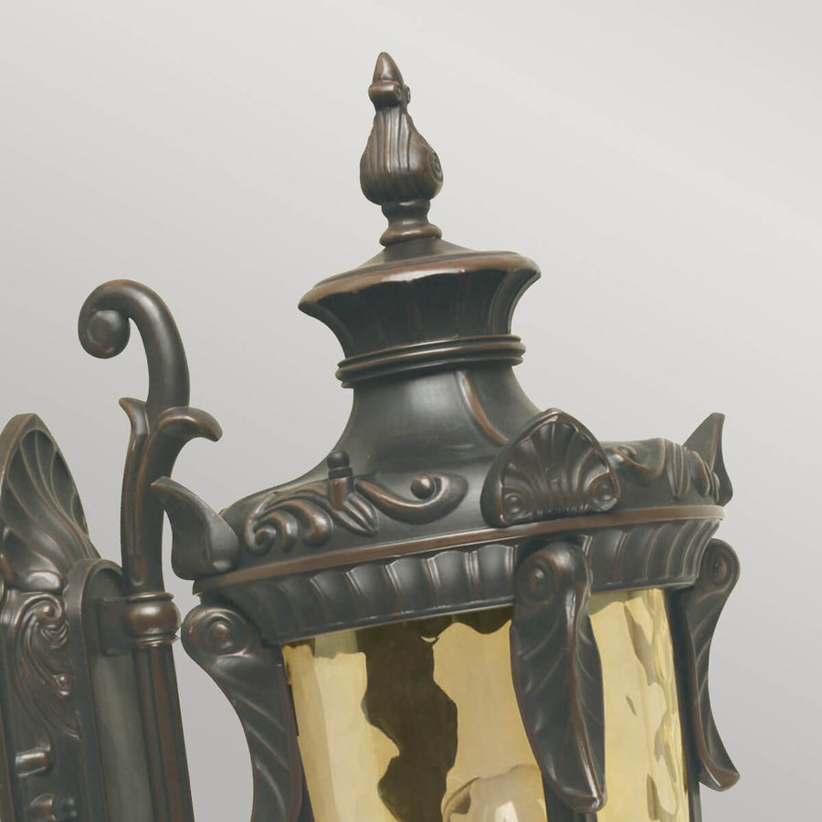 Gros plan sur le sommet mouluré, le fleuron et les feuillages sculptés du chapiteau