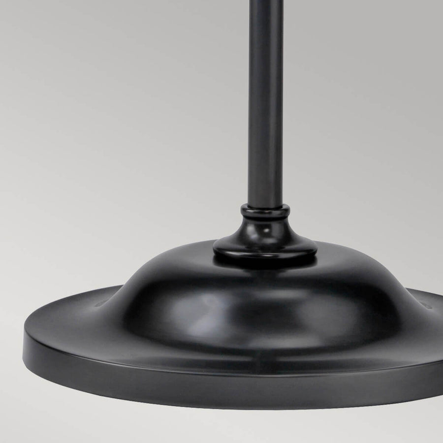 Détail de la base ronde et bombée du pied, finition métal noir satiné.