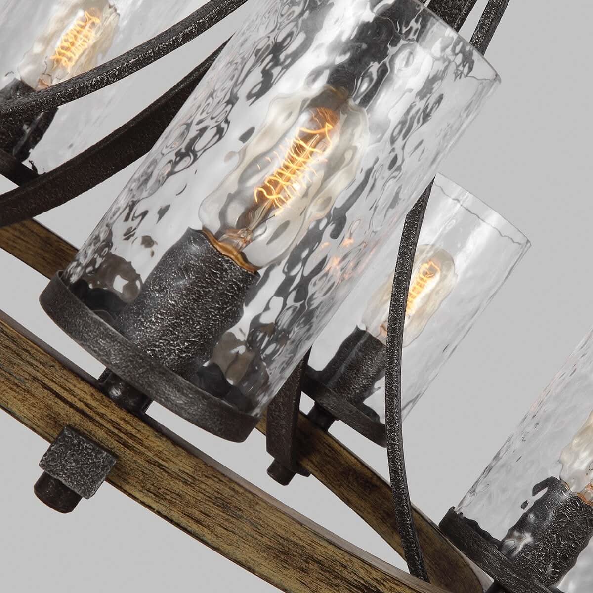 Gros plan sur les cylindres de verre martelé et les ampoules allumées du luminaire
