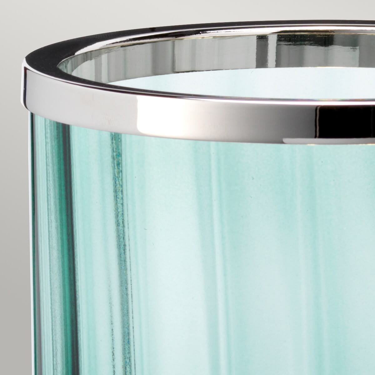 Gros plan sur le cerclage supérieur chromé et le verre vert translucide.