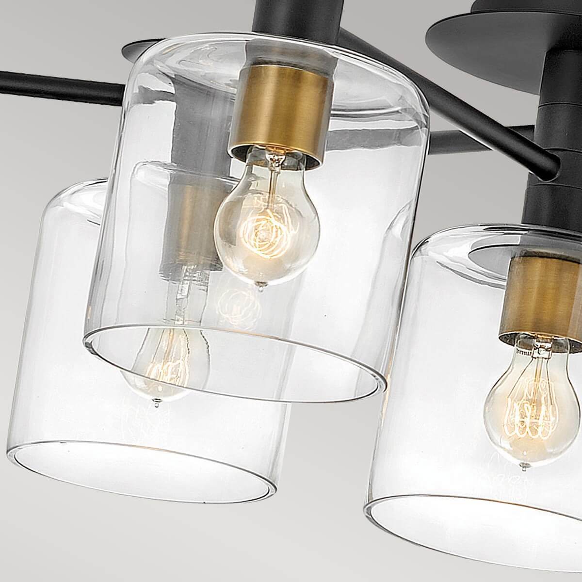 Gros plan sur les diffuseurs cylindriques transparents et les ampoules à filament allumées.