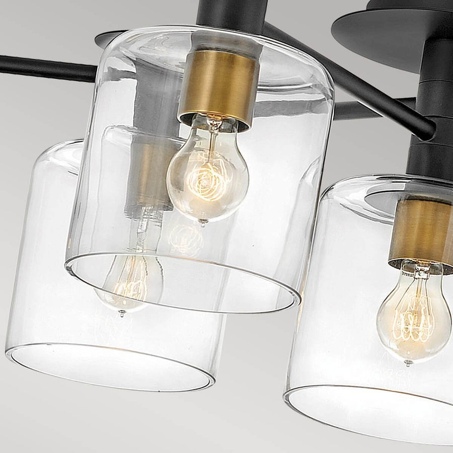 Gros plan sur les diffuseurs cylindriques transparents et les ampoules à filament allumées.