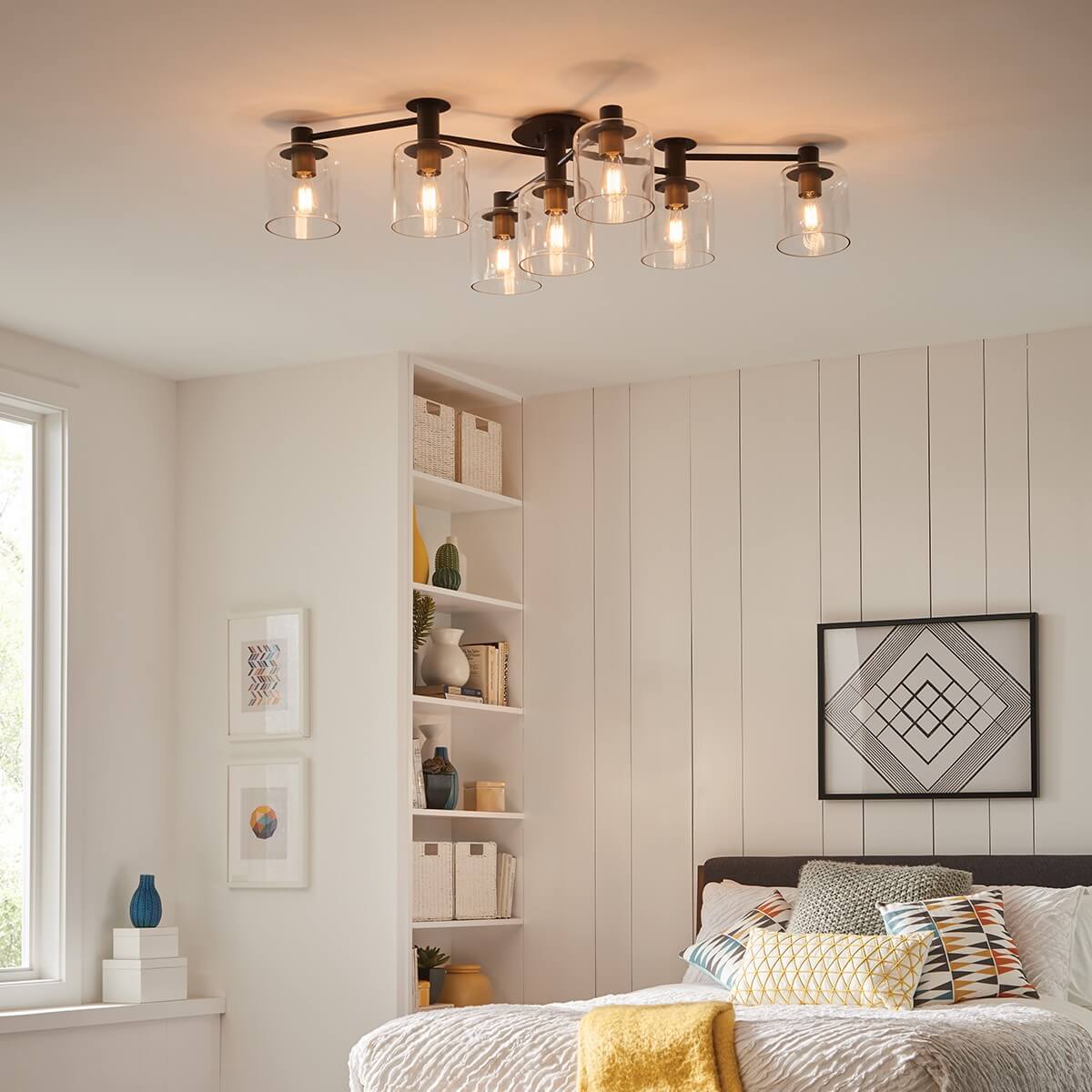 Mise en ambiance dans une chambre, plafonnier allumé au-dessus du lit.