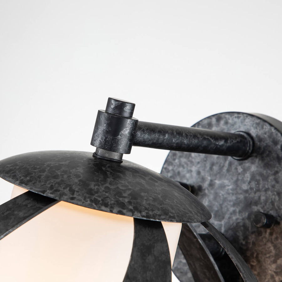 Détail du bras articulé et de la platine ronde au fini zinc martelé sombre