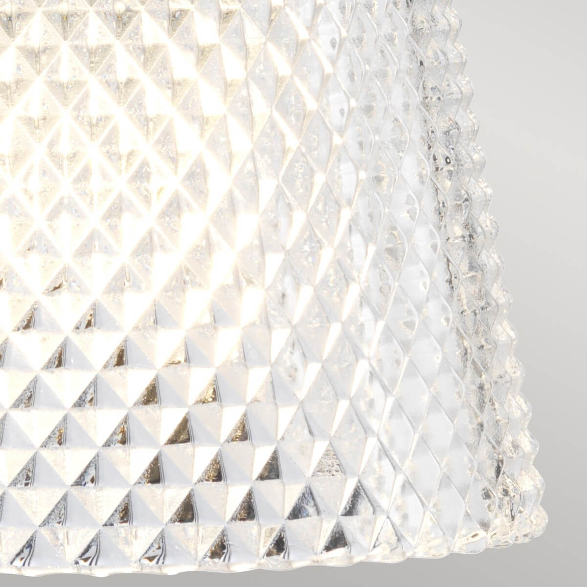 Gros plan sur le verre transparent texturé diffusant une lumière chaude et scintillante
