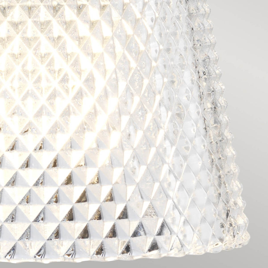 Gros plan sur le verre transparent texturé diffusant une lumière chaude et scintillante