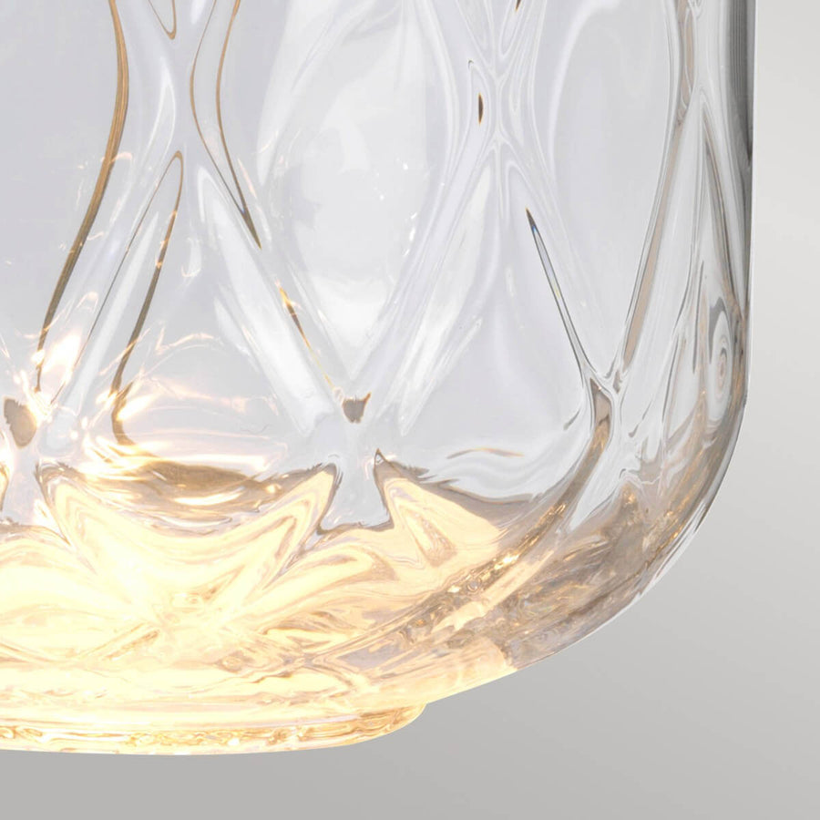 Gros plan du bas du globe en verre illuminé aux reflets dorés et ondulés