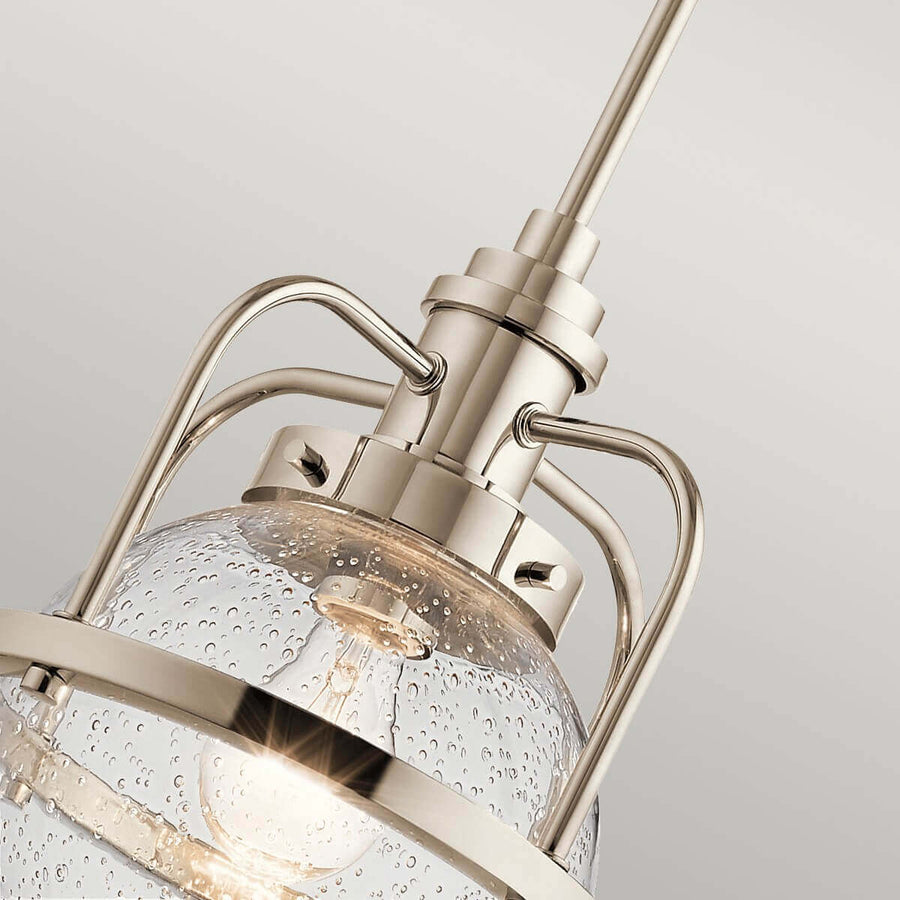 Gros plan sur la cage métallique, le verre cloqué et l’ampoule visible à l’intérieur.