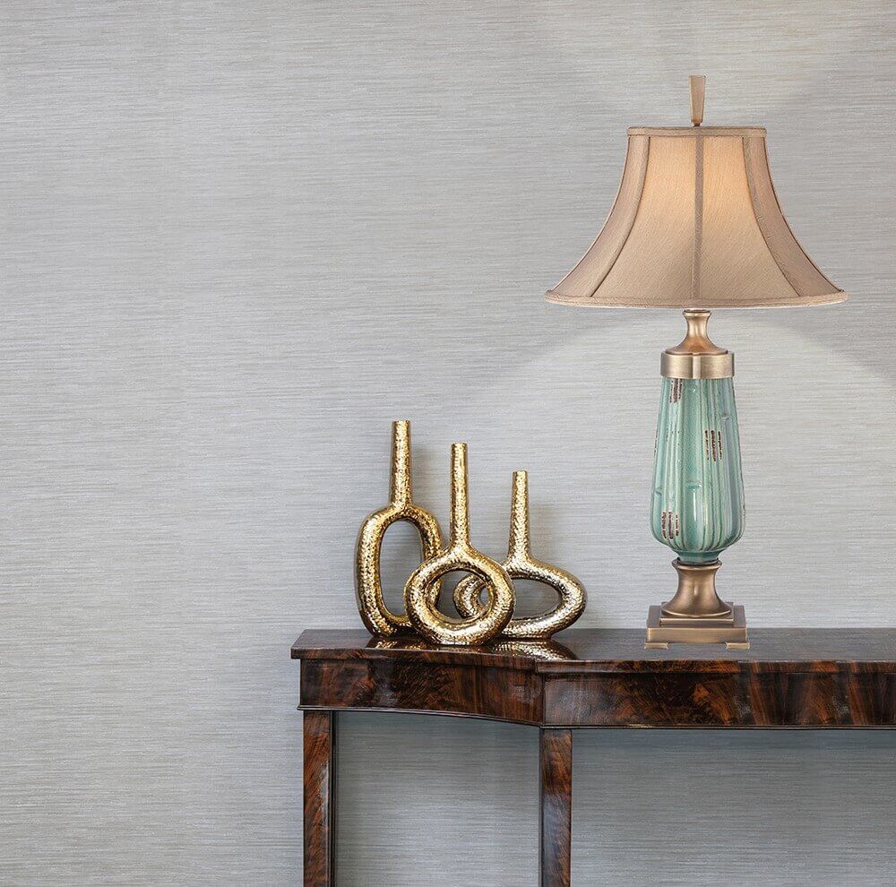Lampe posée sur une console en bois, mise en ambiance avec objets dorés