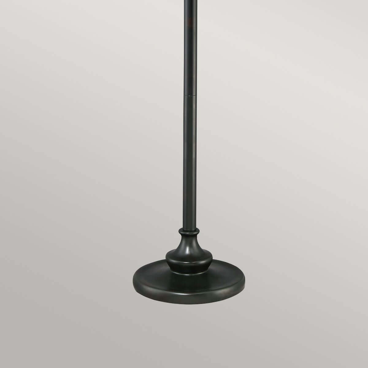Détail de la base circulaire et du pied cylindrique en métal bronze foncé