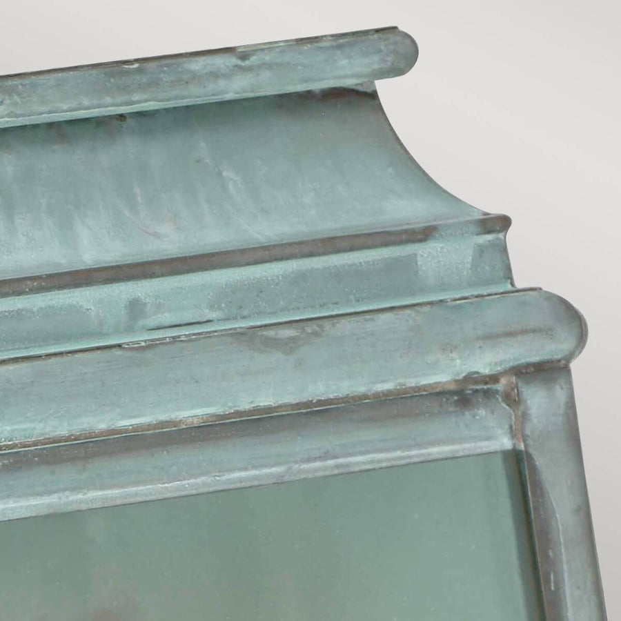 Détail du chapiteau mouluré et de la patine vert-de-gris sur le sommet