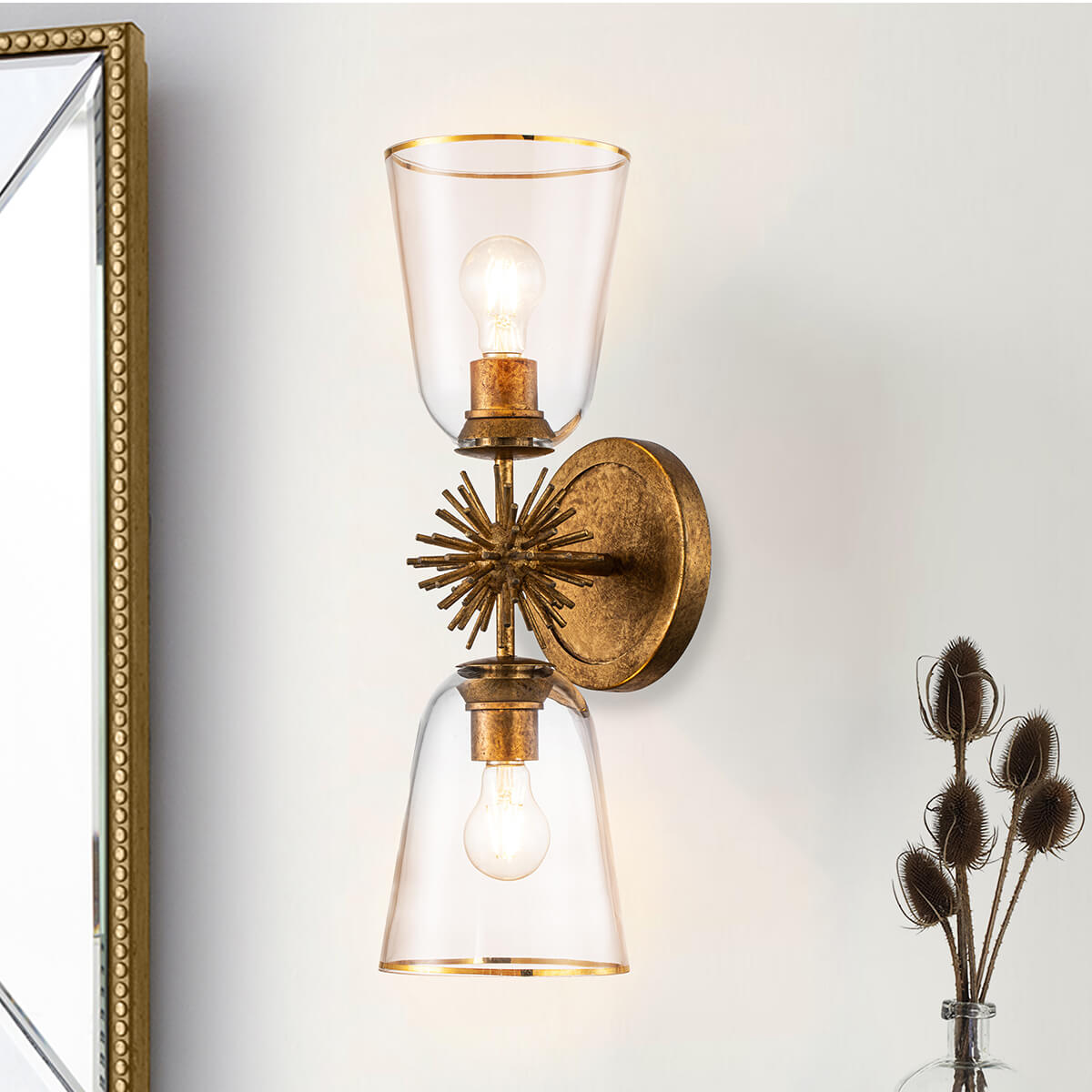 Mise en ambiance de l'applique allumée près d'un miroir et de fleurs séchées