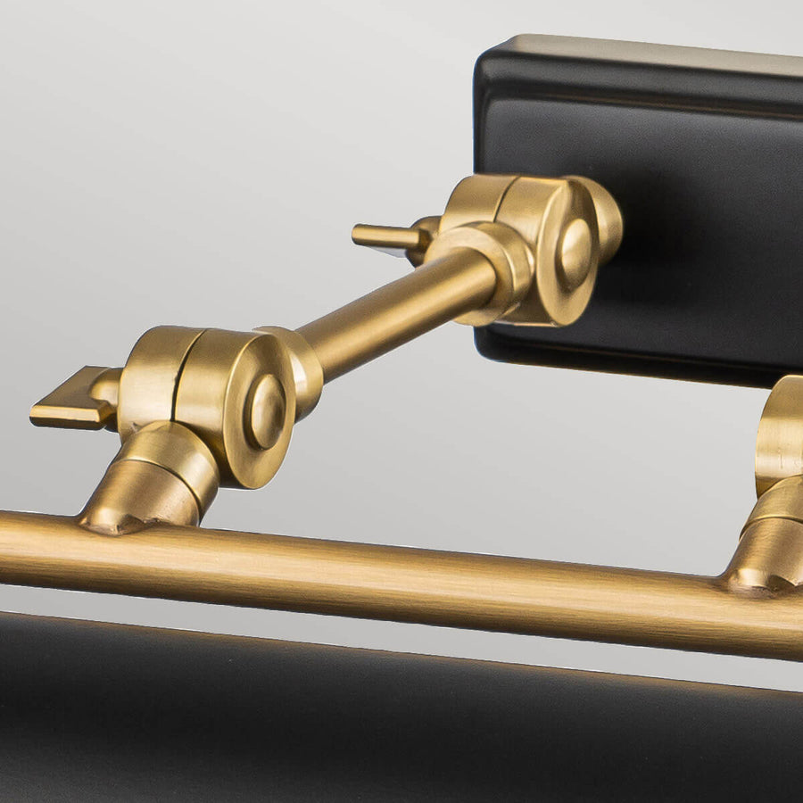 Gros plan sur l'articulation orientable en laiton vieilli de l'applique