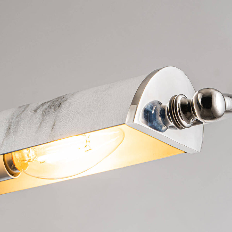Vue rapprochée de l'ampoule allumée sous le diffuseur en verre et la finition nickel