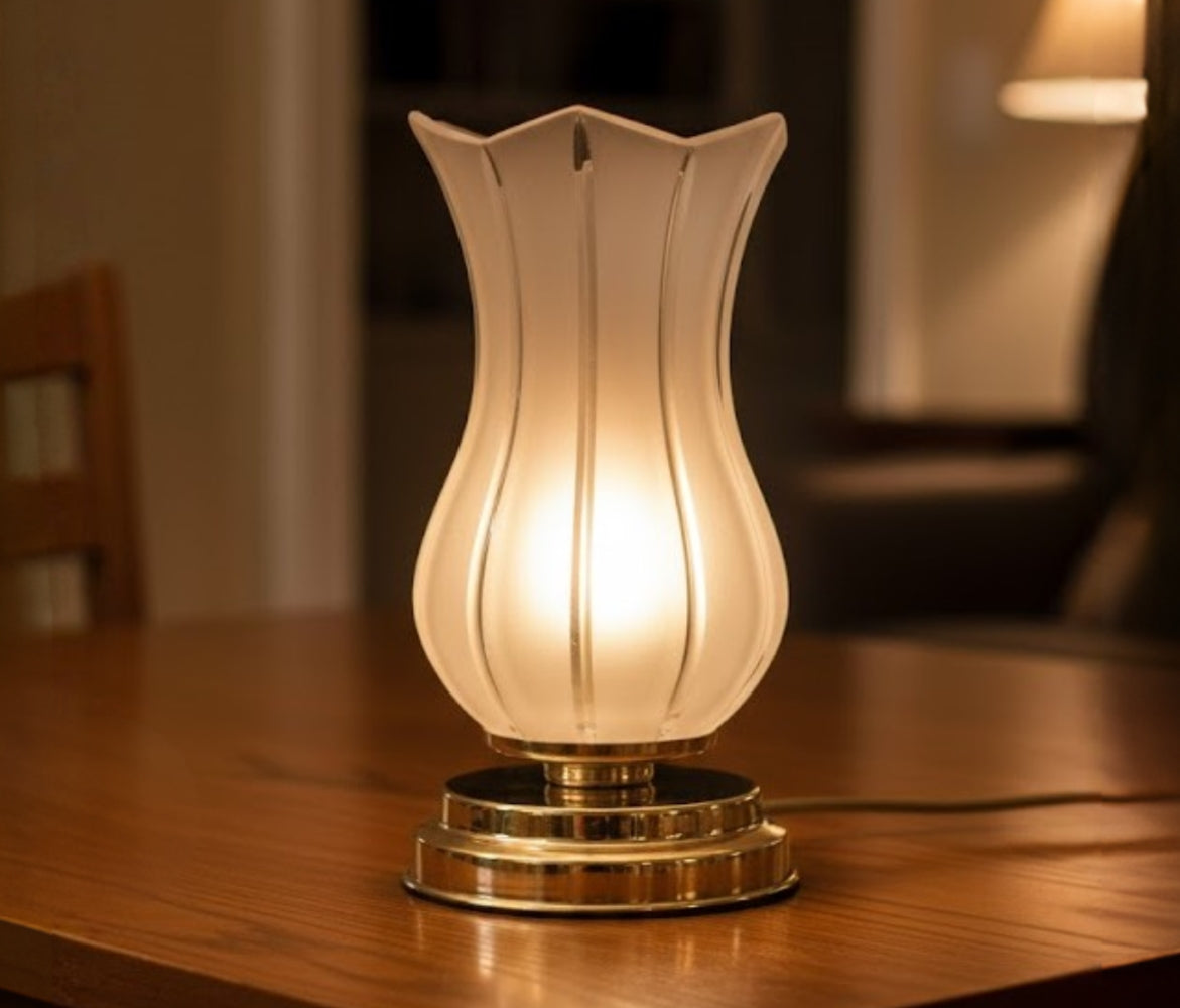 Lampe allumée en ambiance, posée sur table en bois, lumière chaude tamisée.