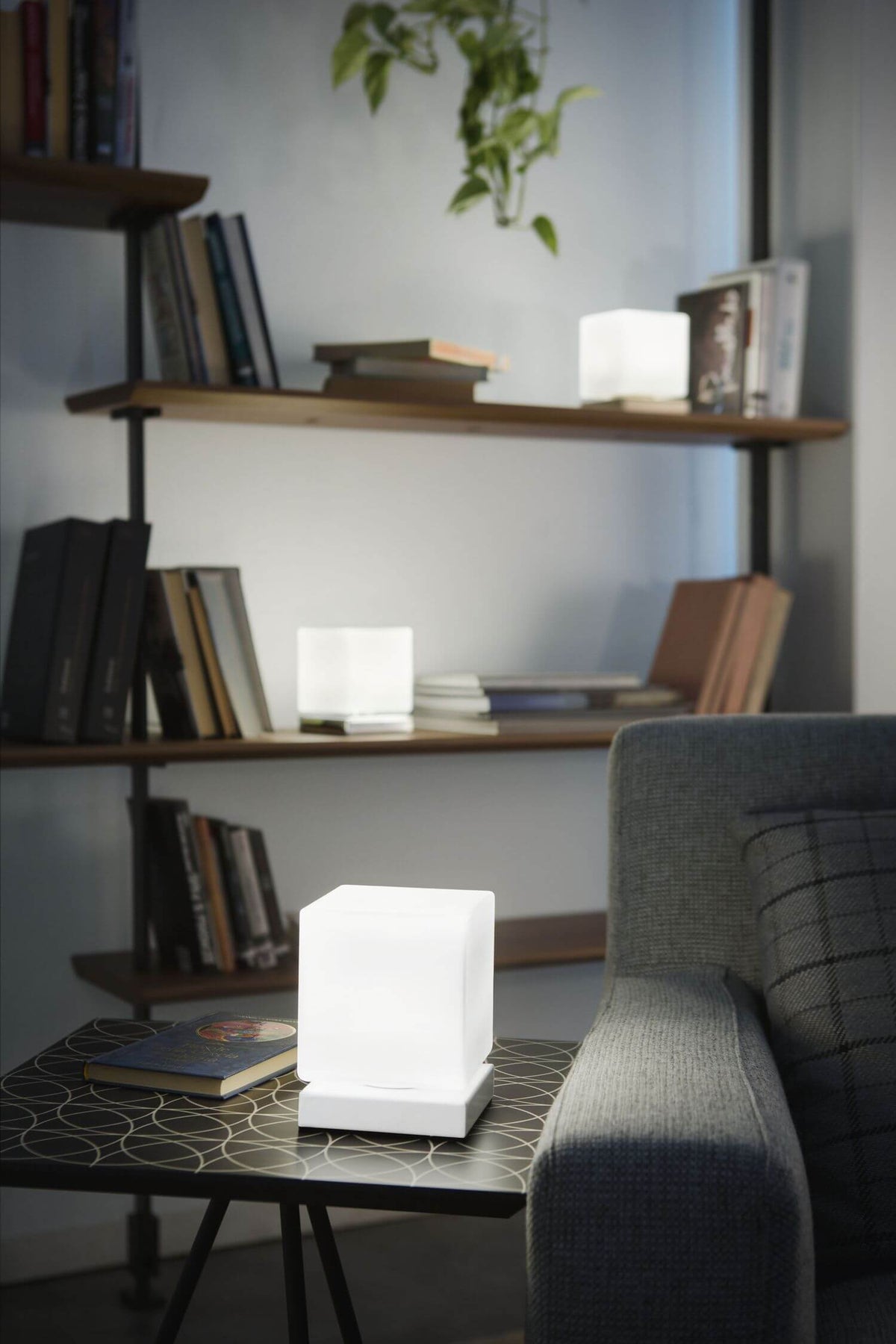 Mise en ambiance du cube lumineux posé sur une table près d'un fauteuil