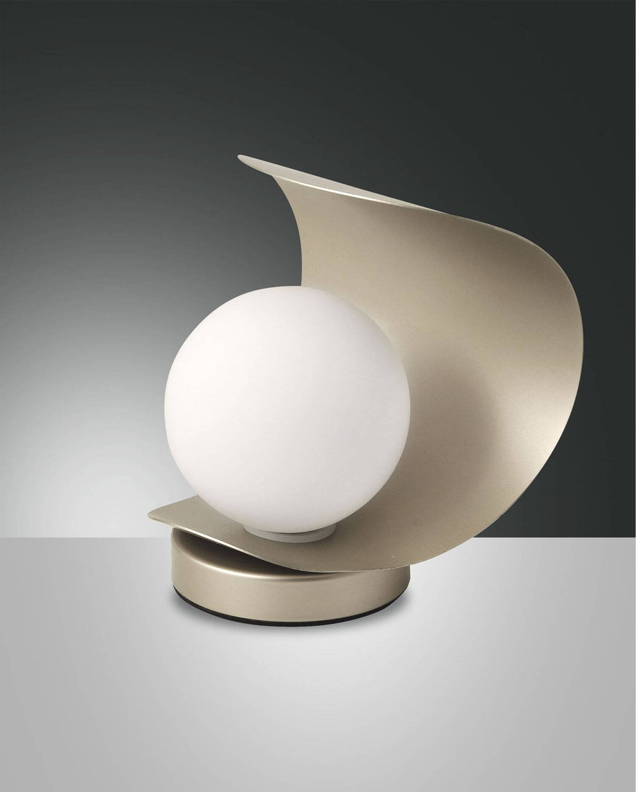 Lampe à poser dorée vue de face sur fond gris dégradé