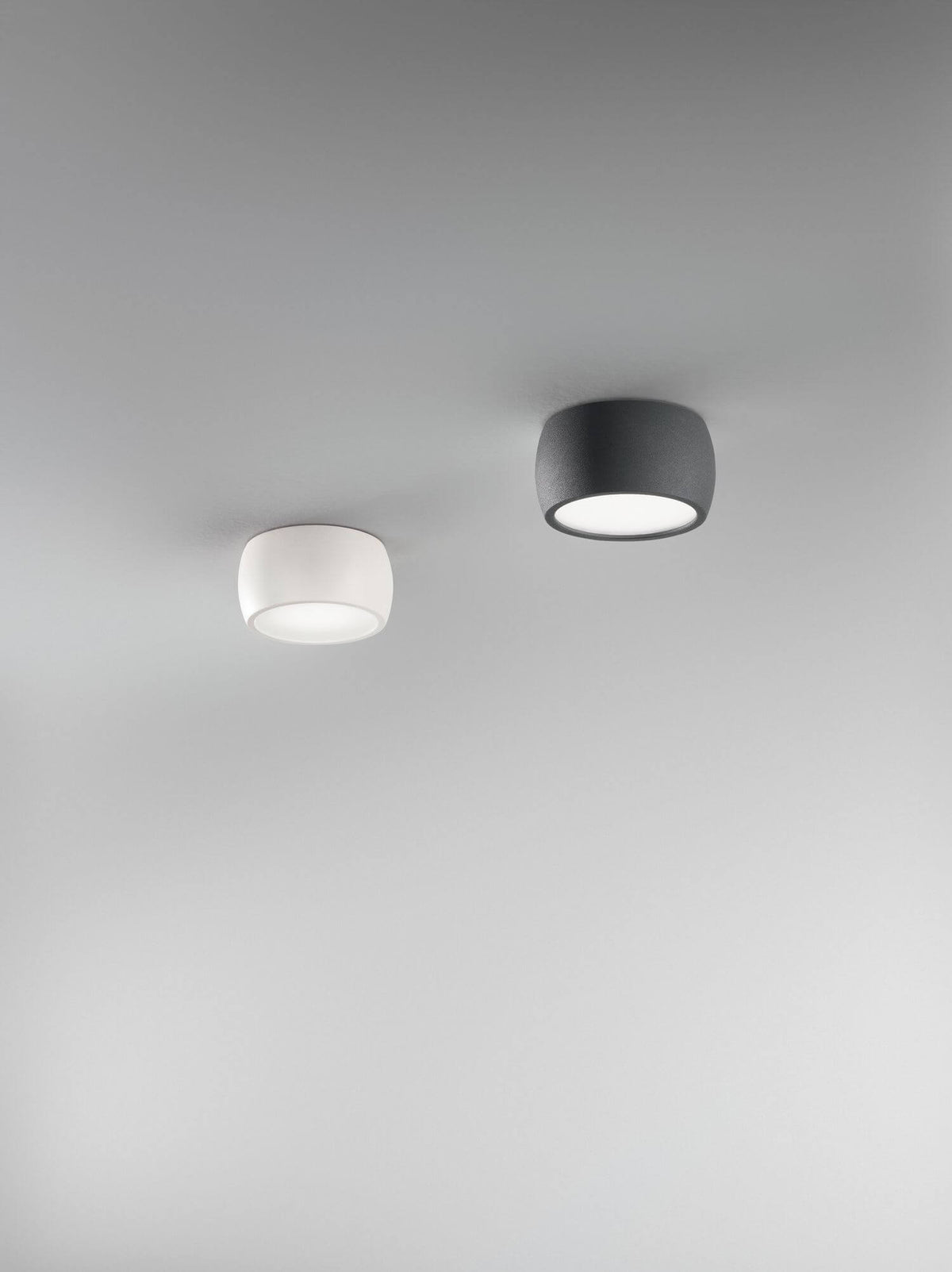 Deux spots plafond, un blanc et un gris foncé, vus de dessous