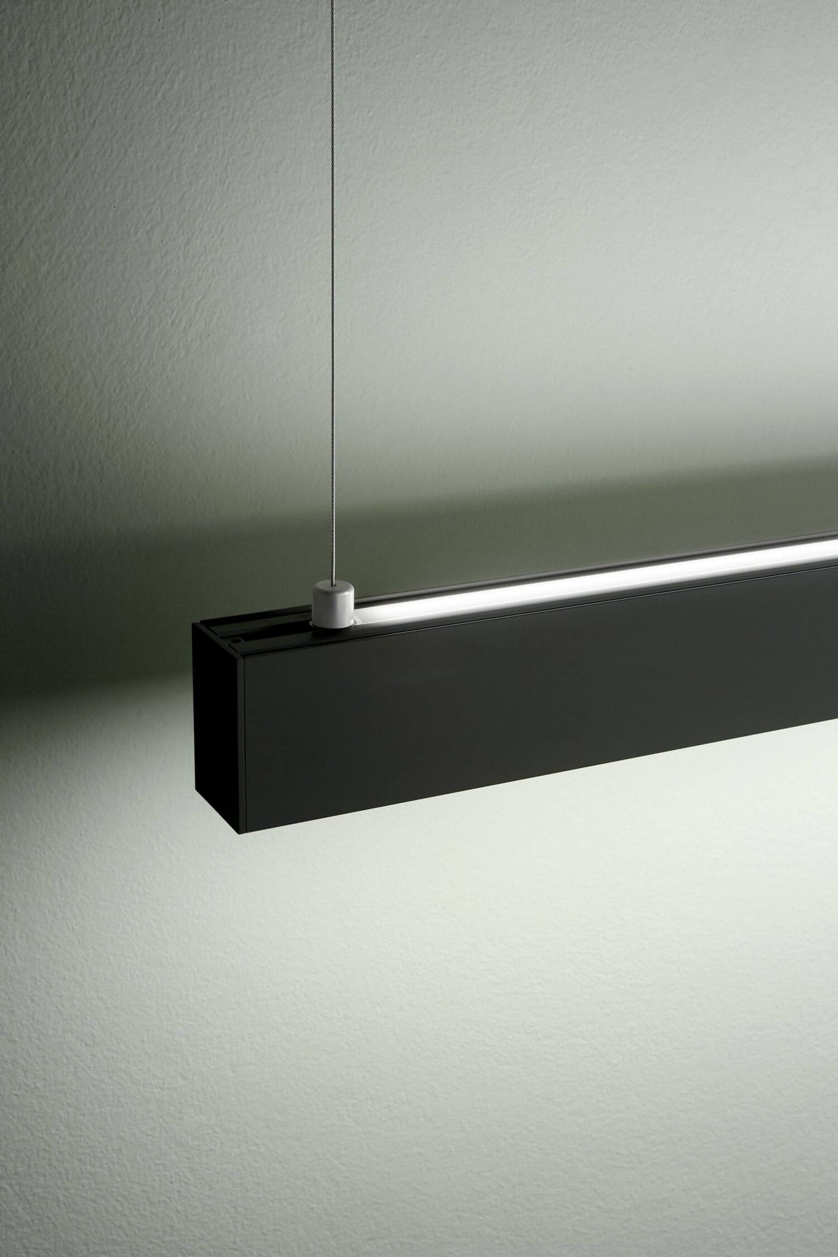 Détail du profil rectangulaire noir et du câble de fixation sur le dessus