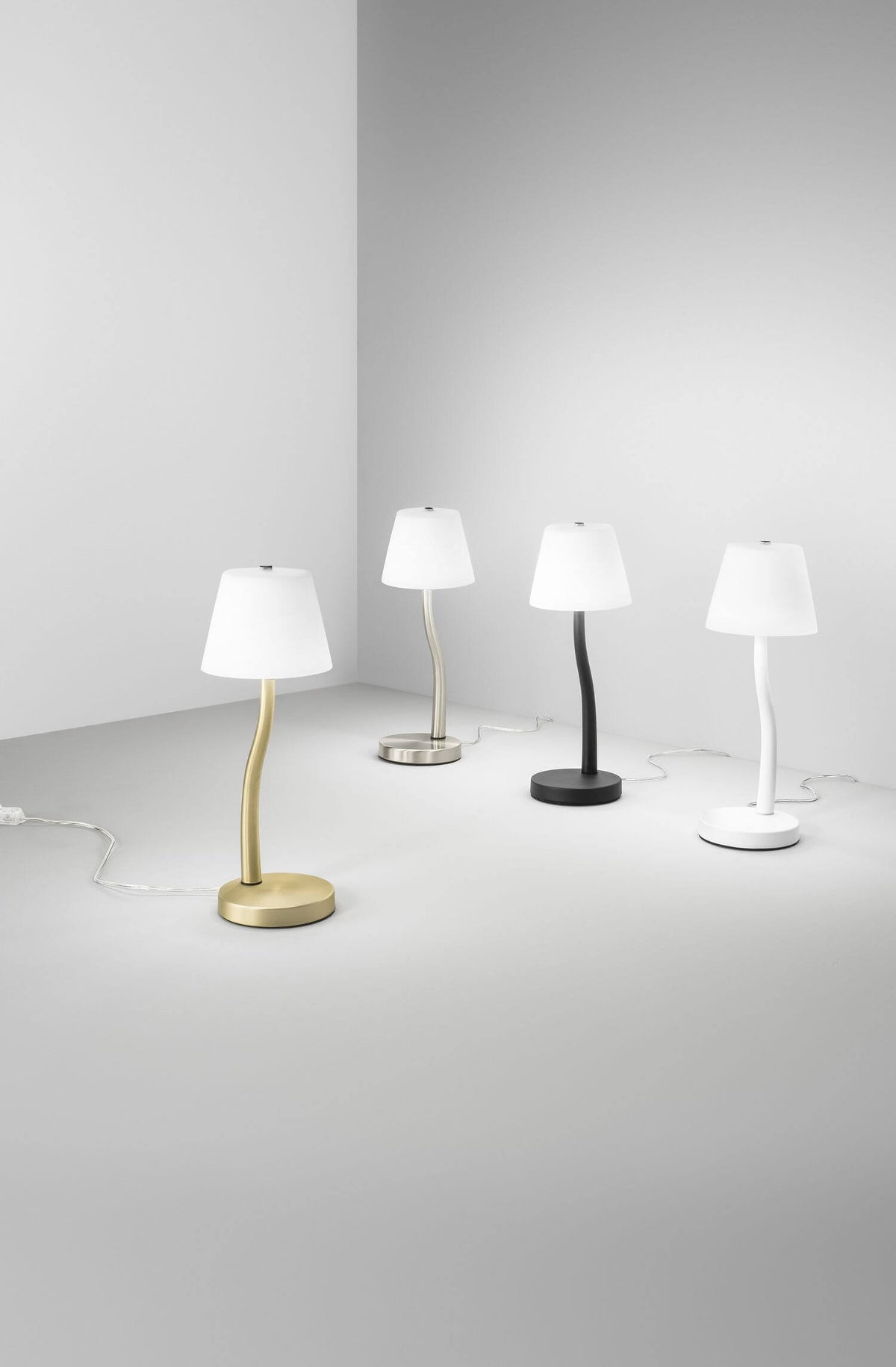 Quatre variantes colorées de la lampe alignées dans un studio blanc minimaliste
