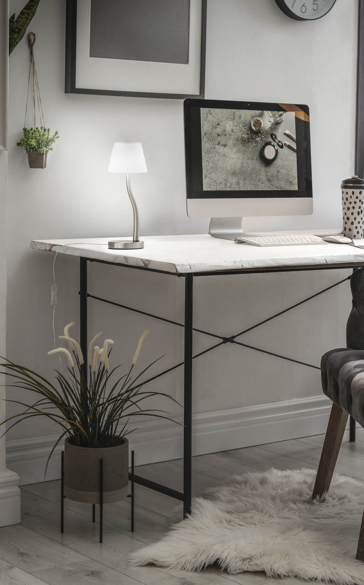 Mise en ambiance sur un bureau blanc, lampe allumée près d'un ordinateur