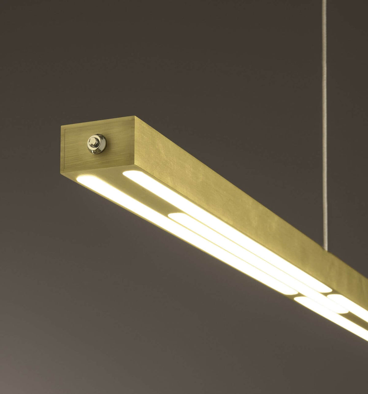 Détail du profilé en laiton brossé et de ses deux bandeaux LED allumés