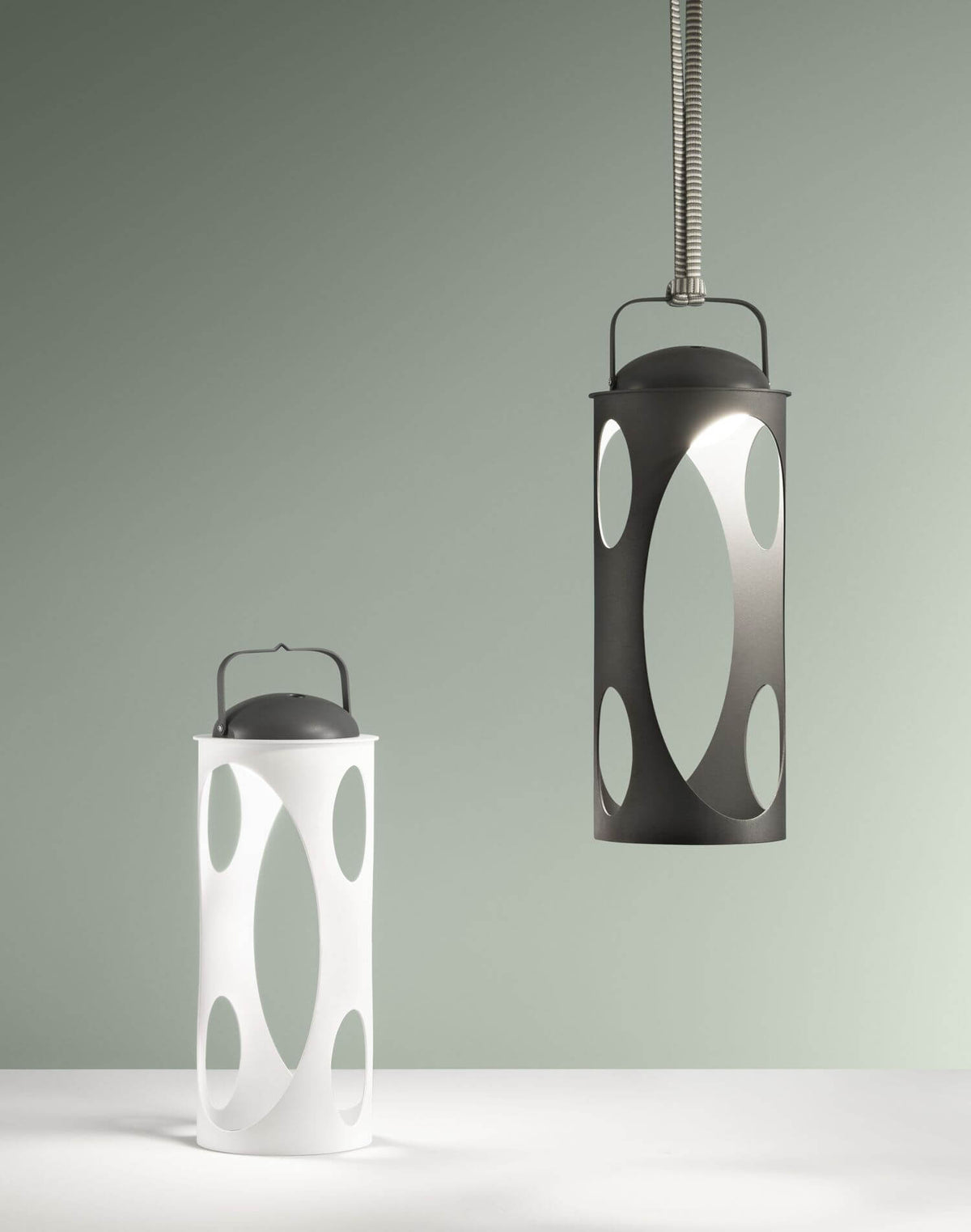 Deux lanternes comparées, une noire suspendue et une blanche posée