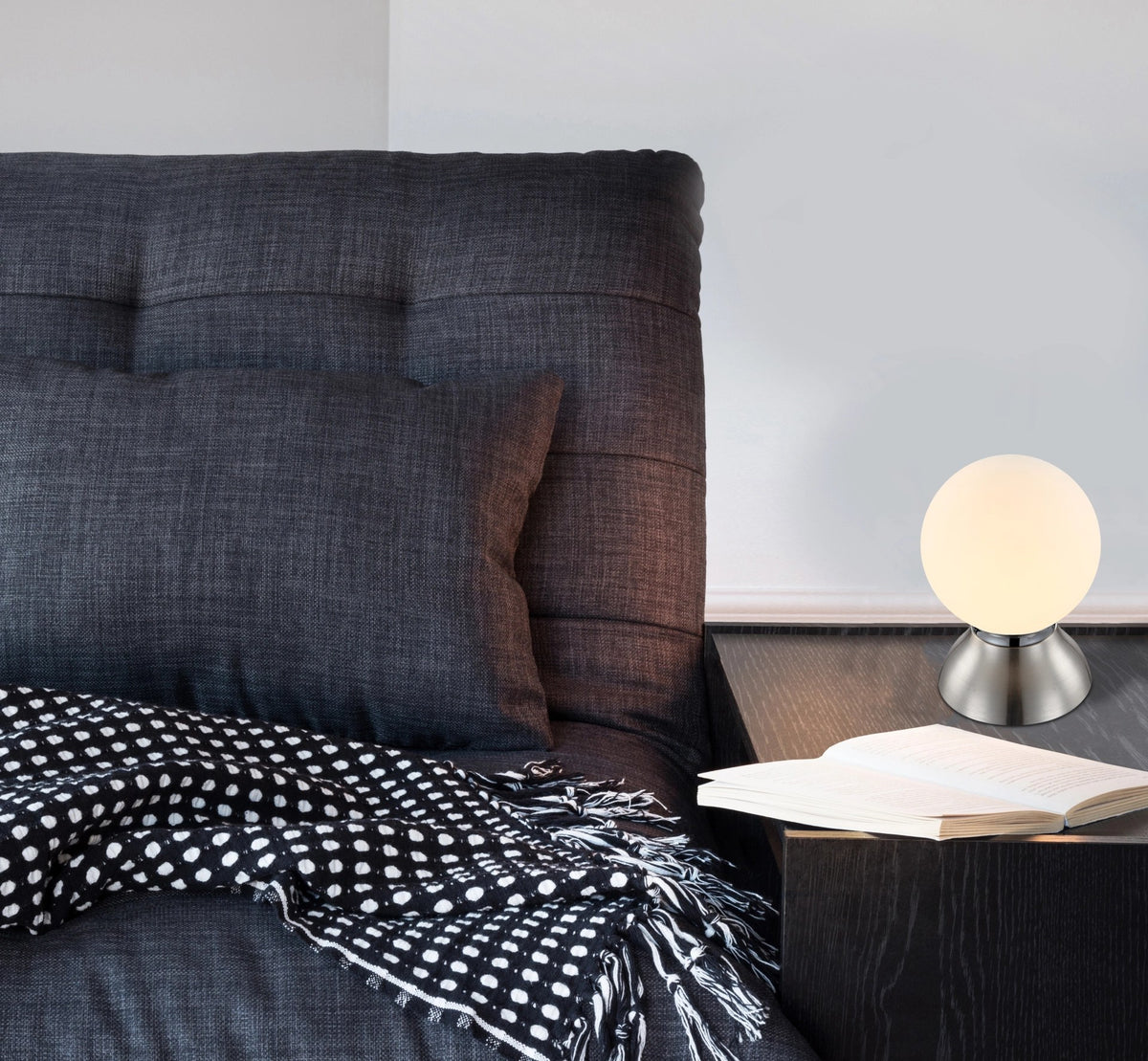 Mise en ambiance sur une table de chevet avec livre ouvert et lit