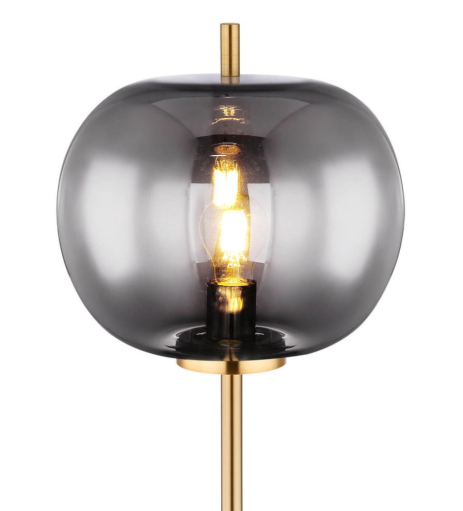 Gros plan sur l'abat-jour en verre fumé et l'ampoule allumée à l'intérieur.