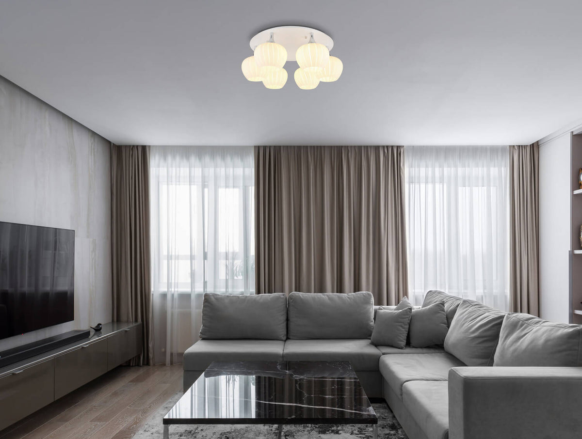 Mise en ambiance dans un salon gris avec canapé, rideaux et grande fenêtre