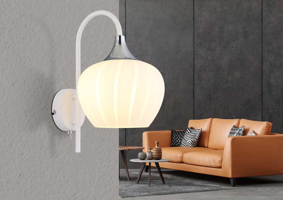 Mise en ambiance : applique murale éclairée fixée sur mur gris, canapé en cuir fauve.