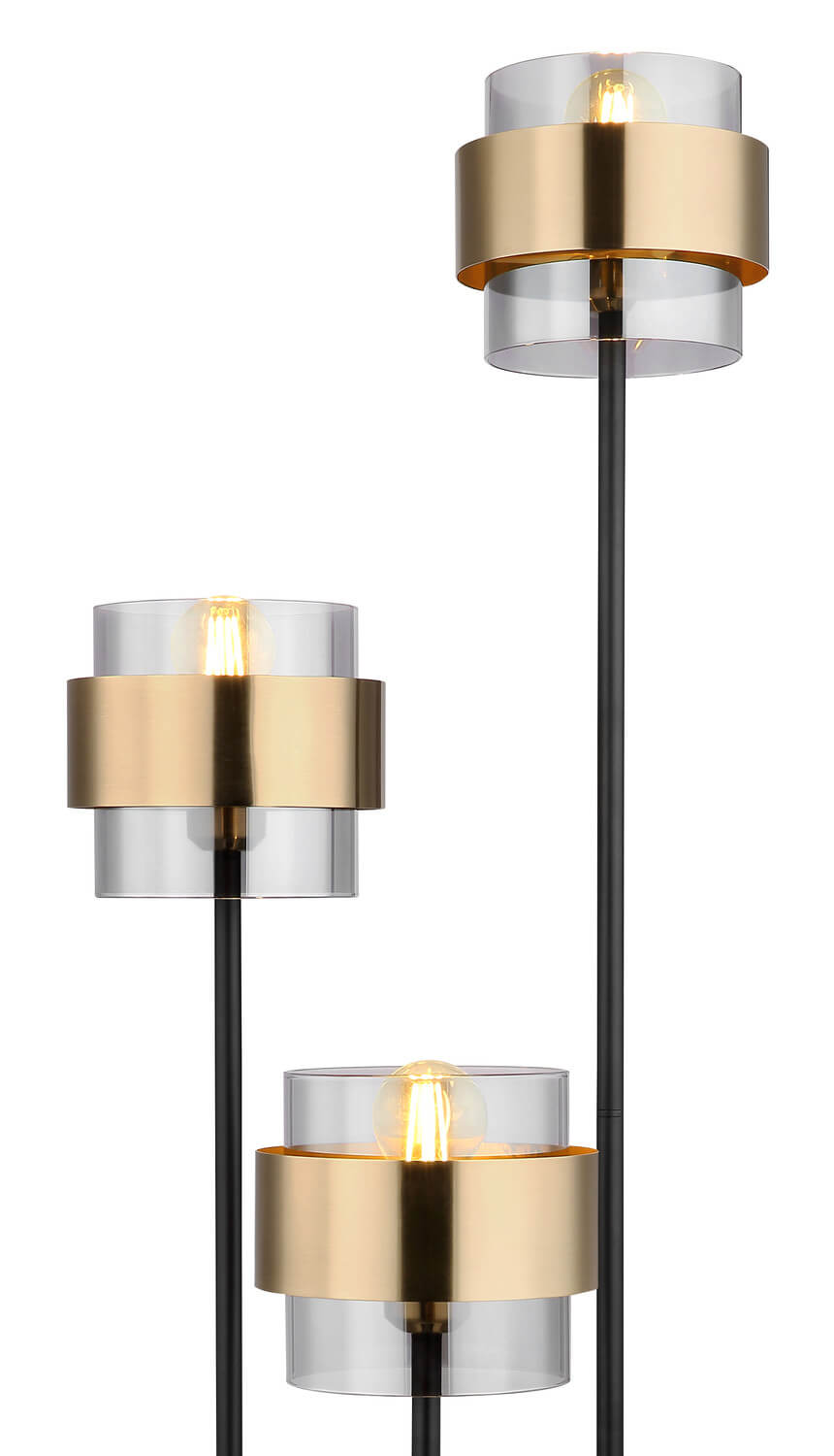 Gros plan sur les trois abat-jours en verre transparent et bandeau laiton, ampoules allumées