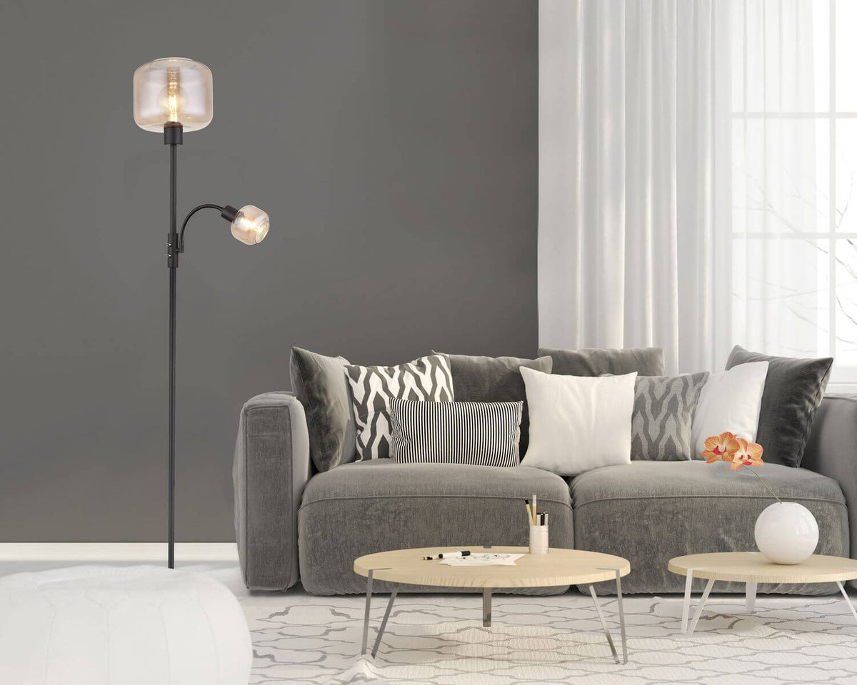 Mise en ambiance dans un salon moderne avec canapé gris, coussins et tables basses