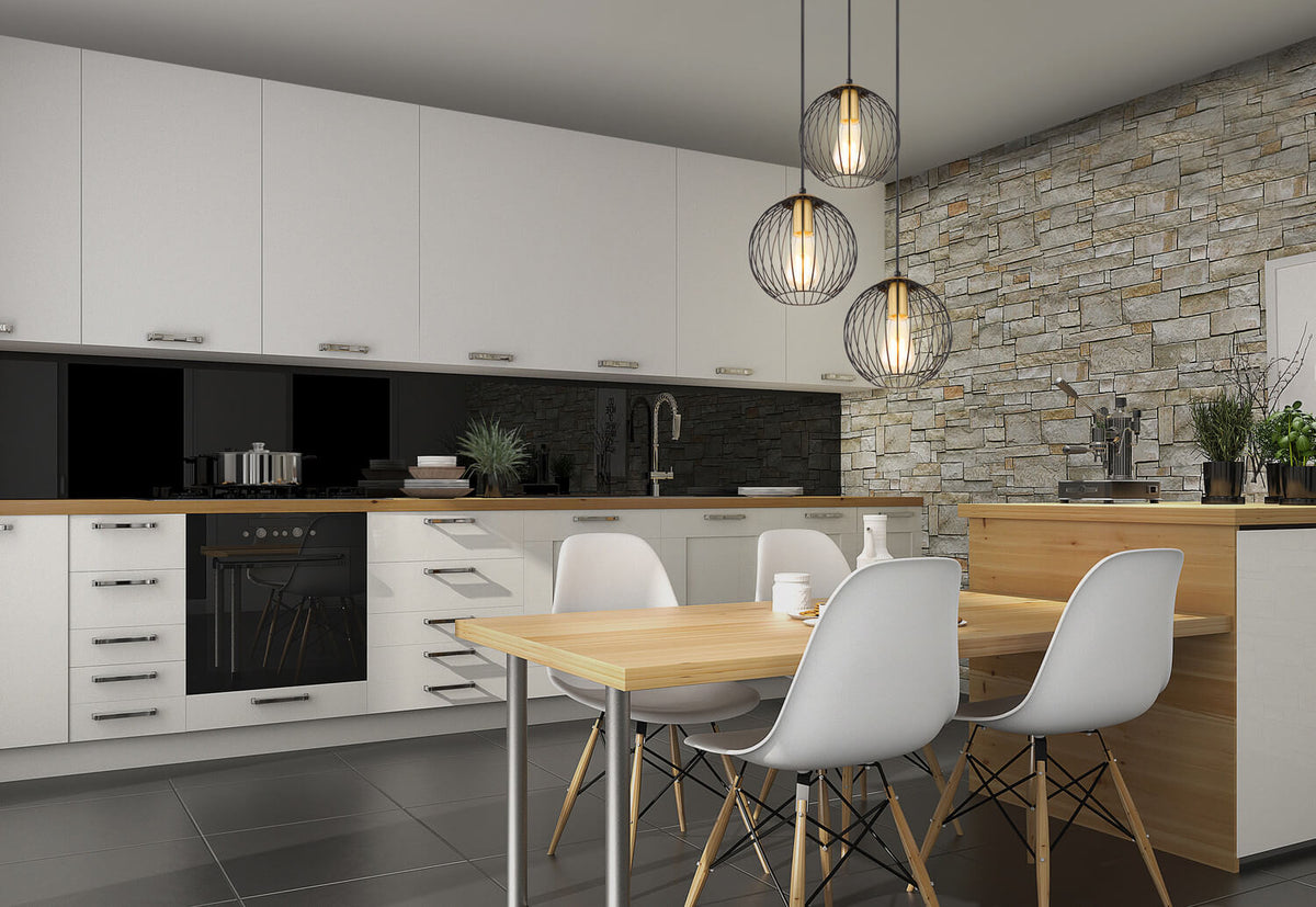 Mise en ambiance dans une cuisine moderne, suspension noire au-dessus d'une table en bois.