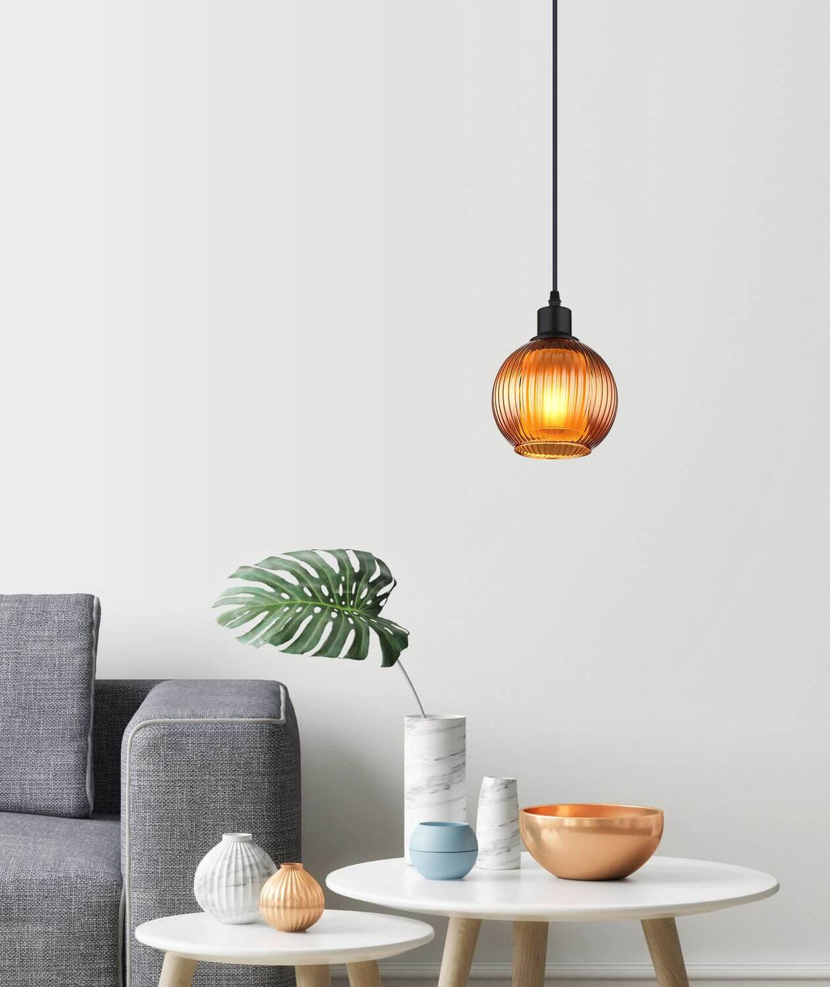 Mise en ambiance du salon avec la suspension allumée au-dessus d'une table.