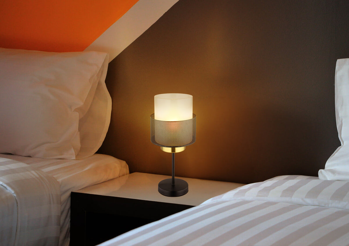 Mise en ambiance nocturne, lampe allumée sur table de nuit près d'un lit