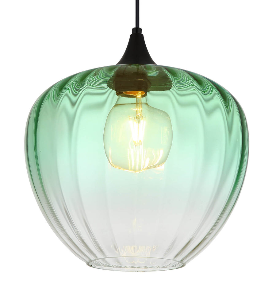 Gros plan sur l'abat-jour en verre vert et l'ampoule à filament allumée.