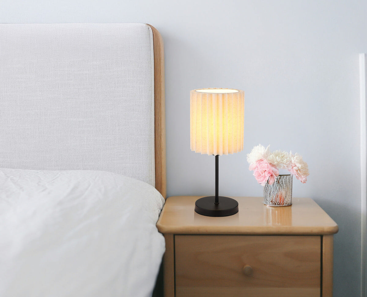 Lampe posée sur une table de chevet en bois, ambiance chambre