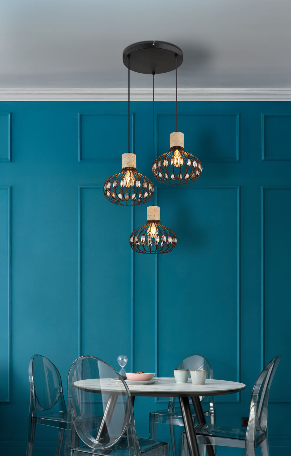 Mise en ambiance au-dessus d'une table ronde devant un mur bleu canard mouluré