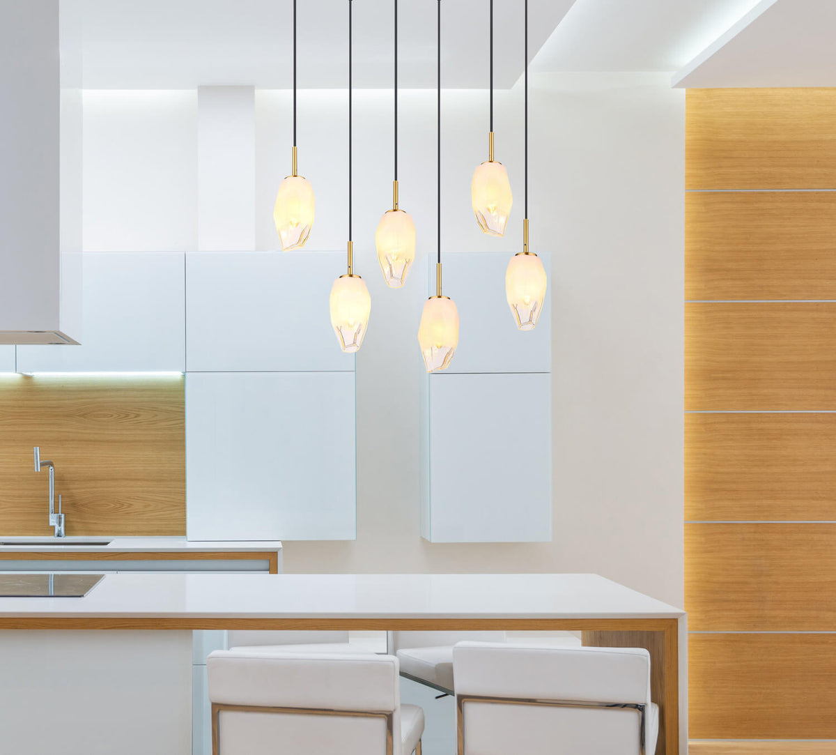 Suspension laiton et verre installée au-dessus d'un îlot de cuisine contemporain avec tabourets blancs