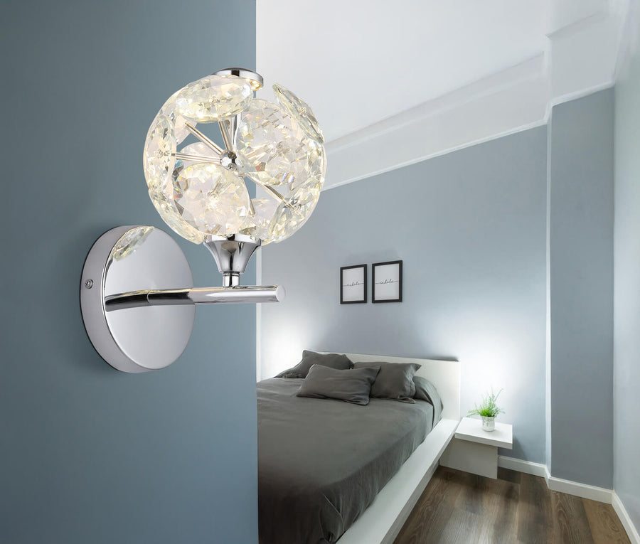 Applique murale allumée fixée au mur bleu d'une chambre, au-dessus d'un lit gris.