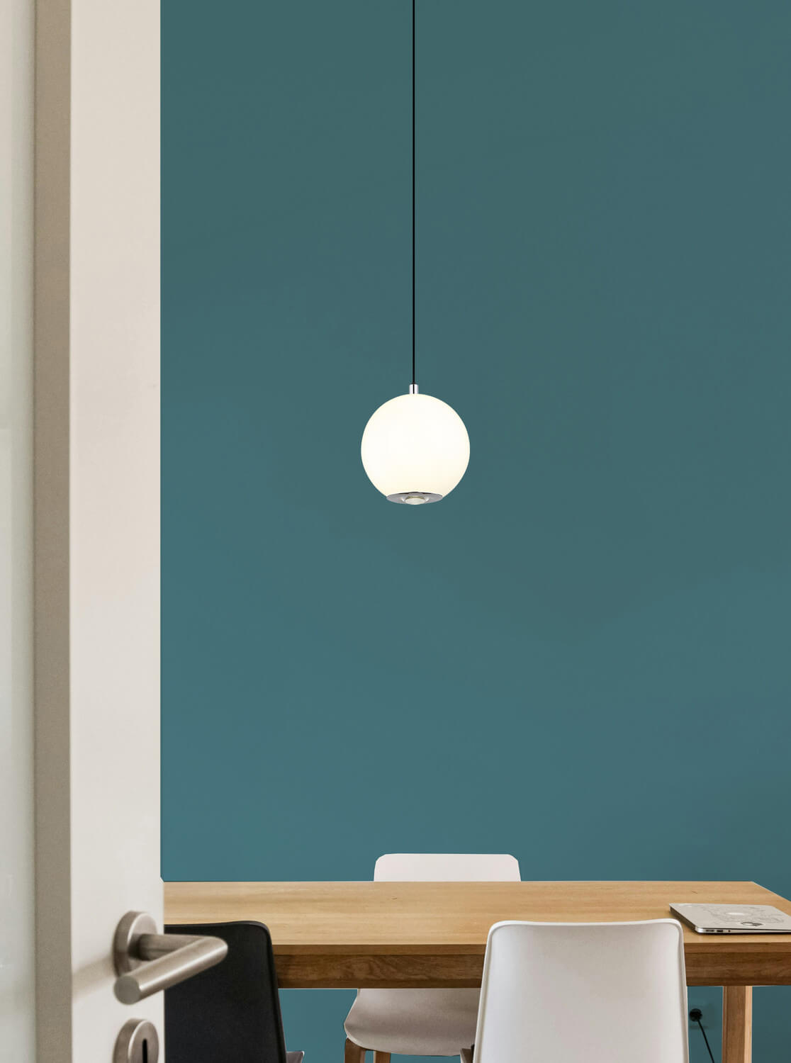 Mise en ambiance au-dessus d'une table en bois devant un mur bleu canard