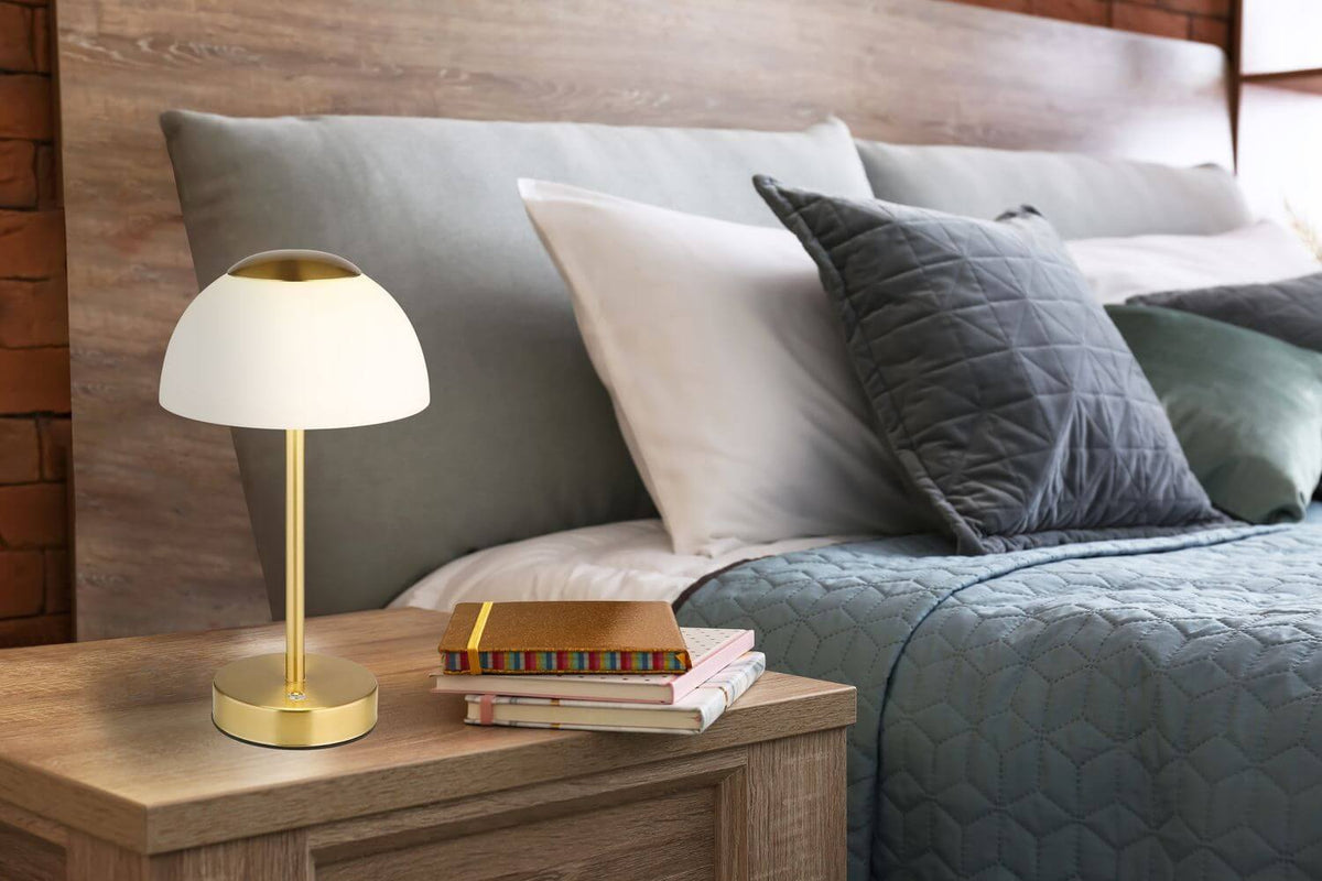 Mise en ambiance, lampe posée sur une table de chevet en bois près du lit