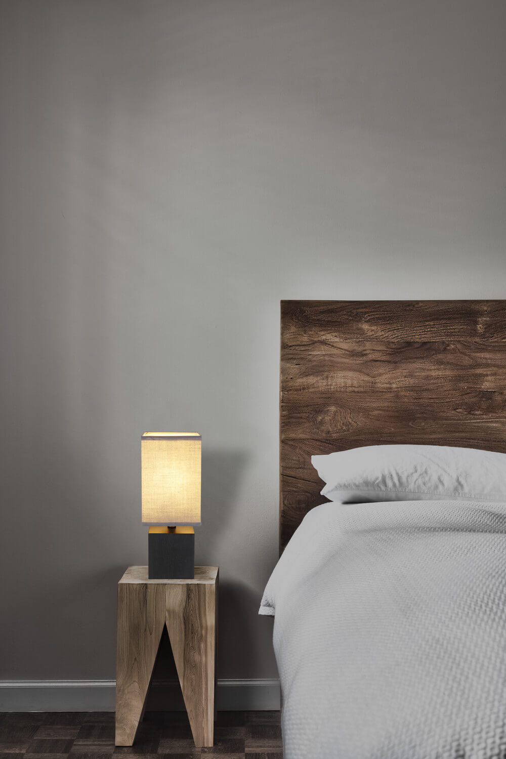 Mise en ambiance de la lampe posée sur une table de chevet en bois