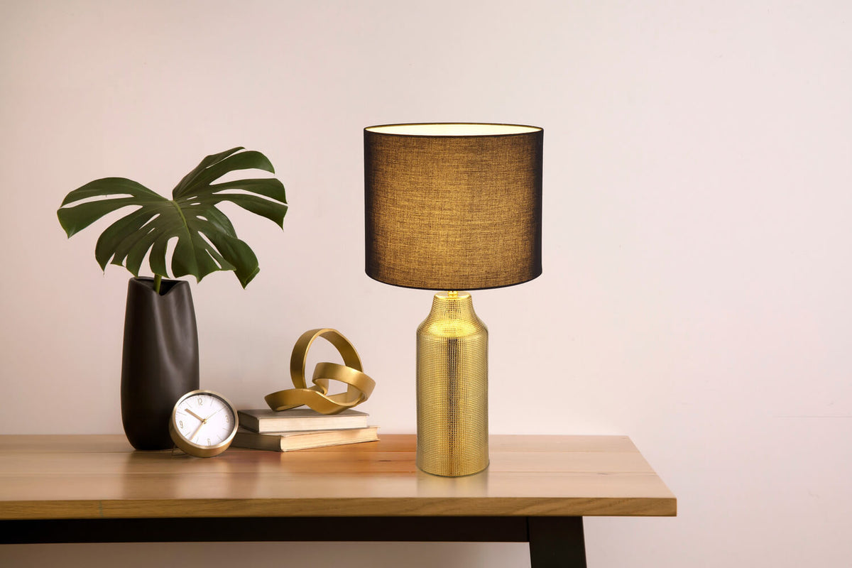 Mise en ambiance sur une table en bois avec plante, réveil et livres décoratifs.