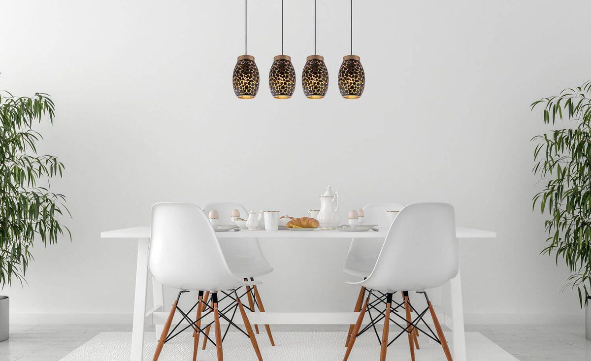 Suspension installée au-dessus d'une table blanche avec chaises et plantes.