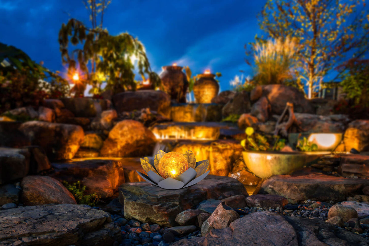 Mise en ambiance nocturne sur des rochers près d'une cascade de jardin