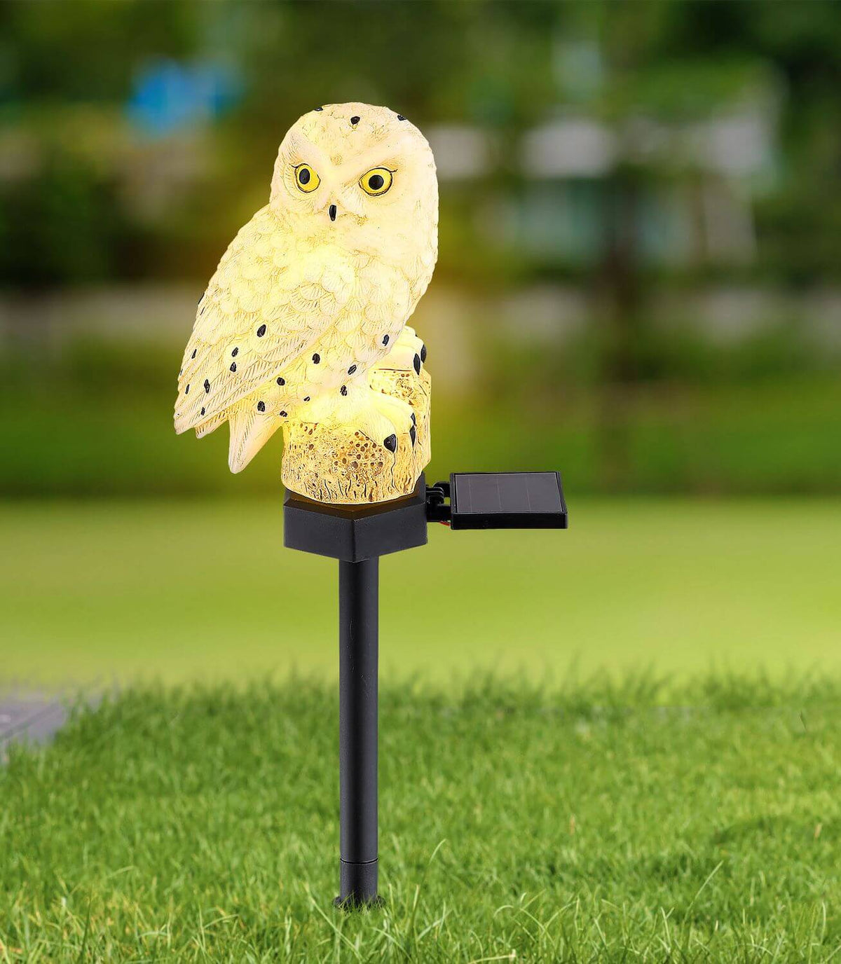 Mise en ambiance dans un jardin, luminaire chouette planté dans la pelouse.