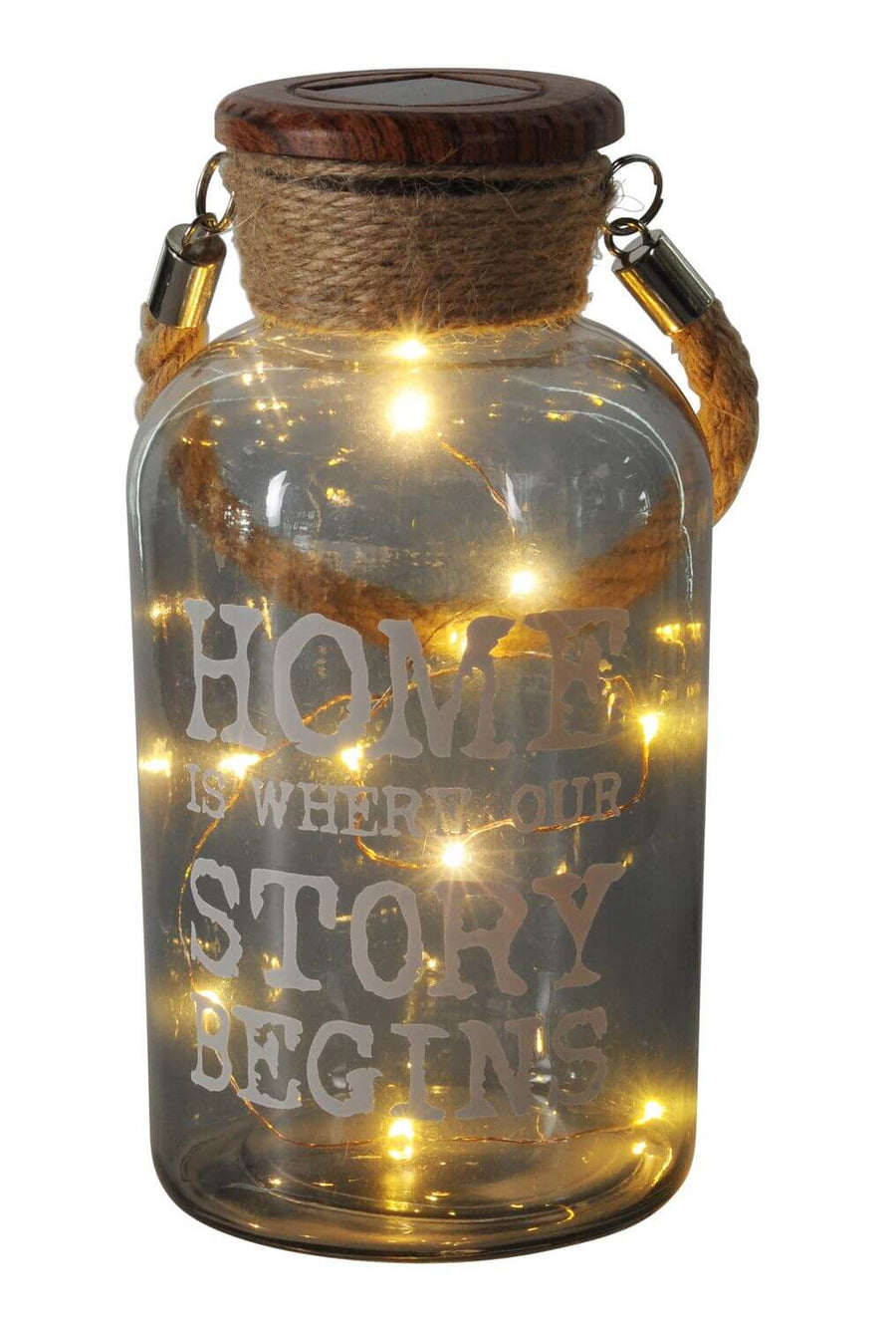 Gros plan sur le bocal lumineux, guirlande LED et inscription HOME IS WHERE OUR STORY BEGINS.